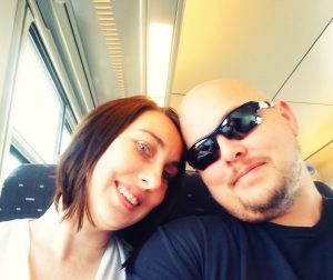 Writer Scott Davis and his wife Erin smiling on a train to Bruges