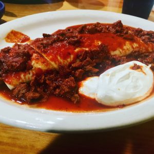A burrito covered in tomato sauce from Los Rancheros.