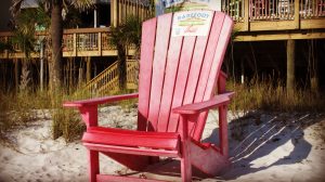 A red chair on the sand outside Barefoot on the Beach restaurant.