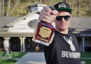 Andrew holds up a bottle of jack Daniels Whiskey