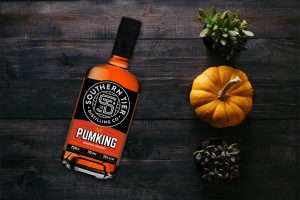 A bottle of Southern Tier Pumking Whiskey next to a pumpkin.